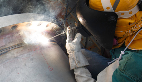 Worker welding pipe